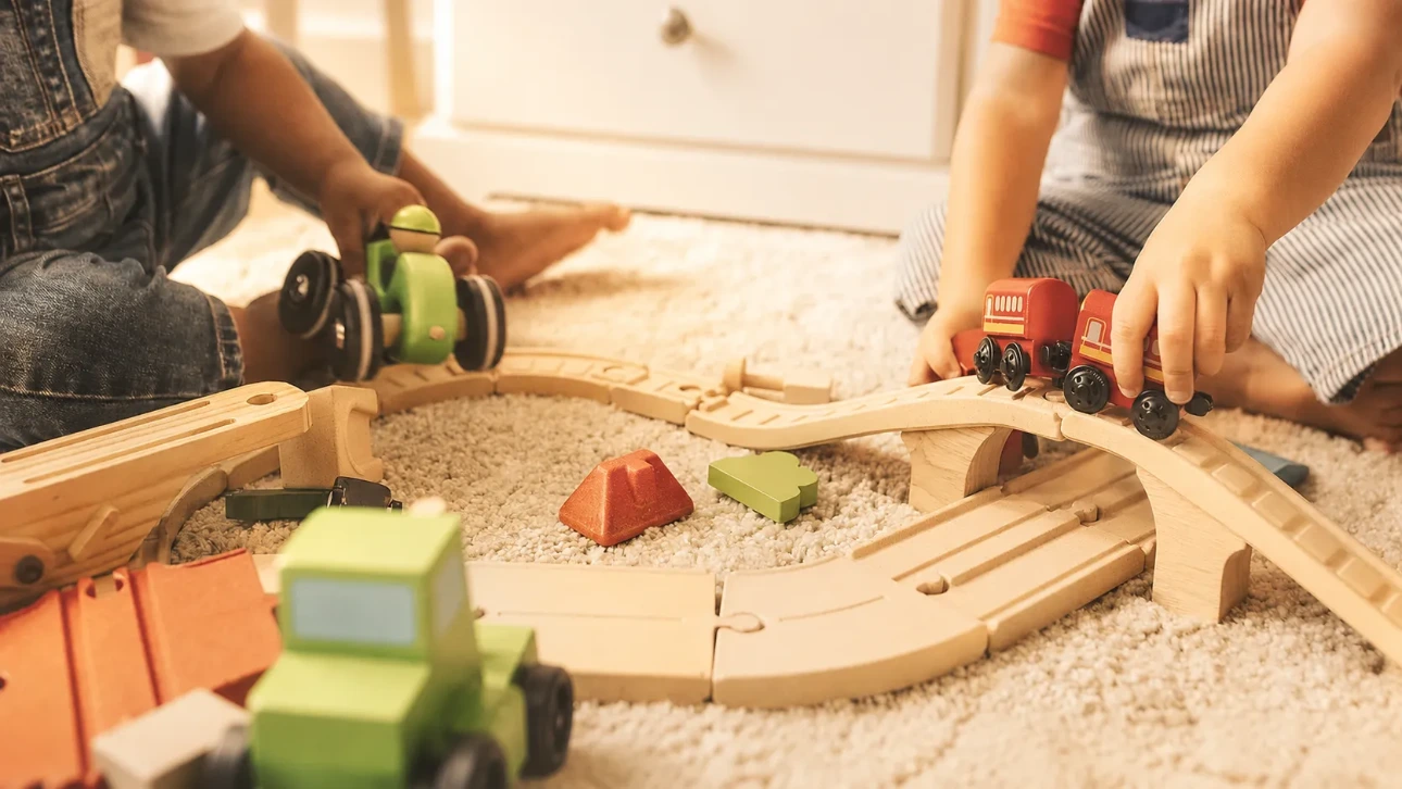 Enfants jouant avec un circuit de train en bois